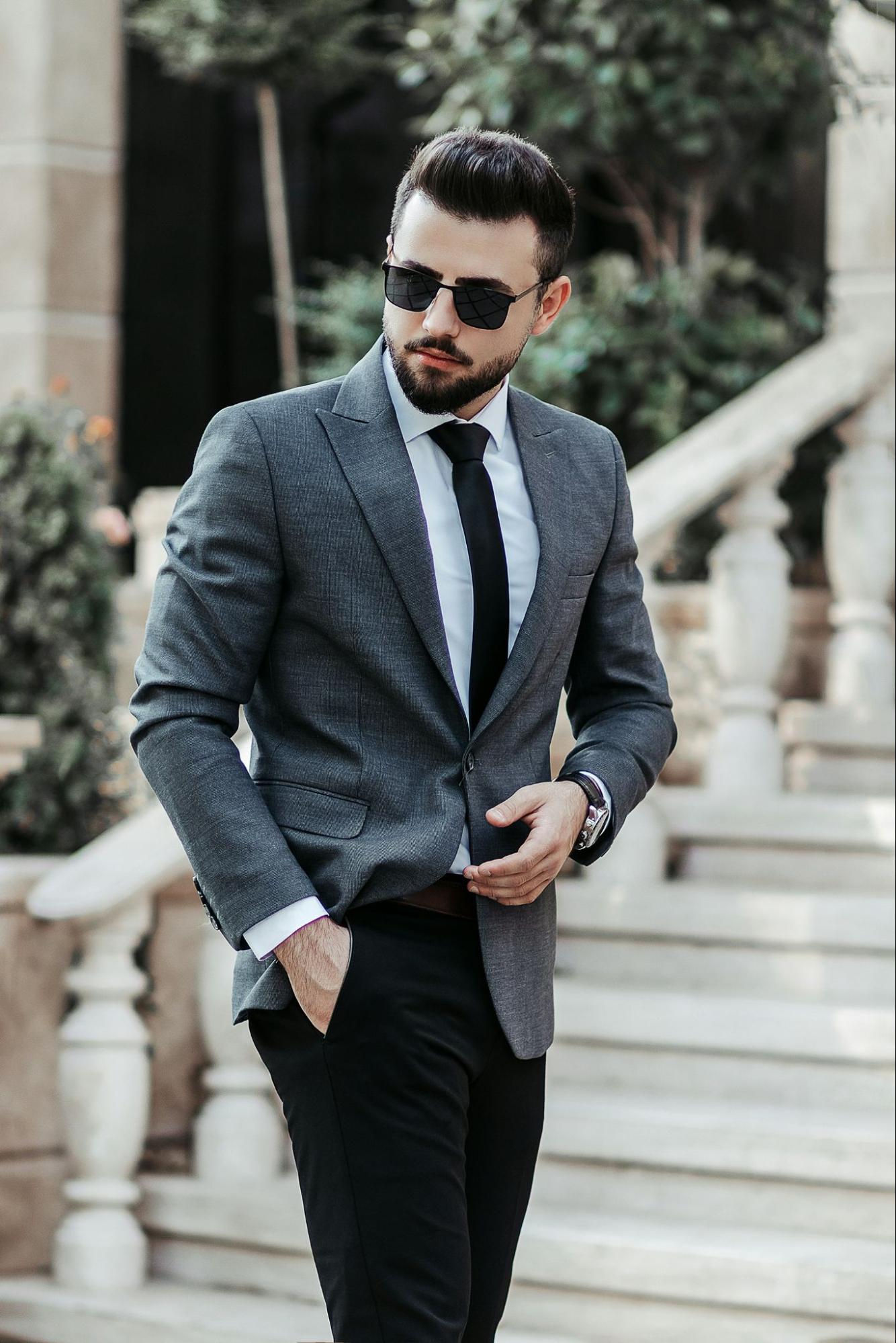 A man in a suit stands on stone steps.