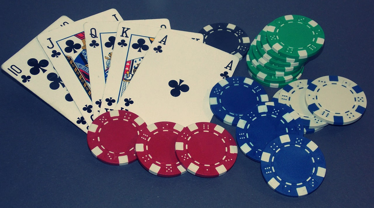 Playing cards and poker chips on a table together.