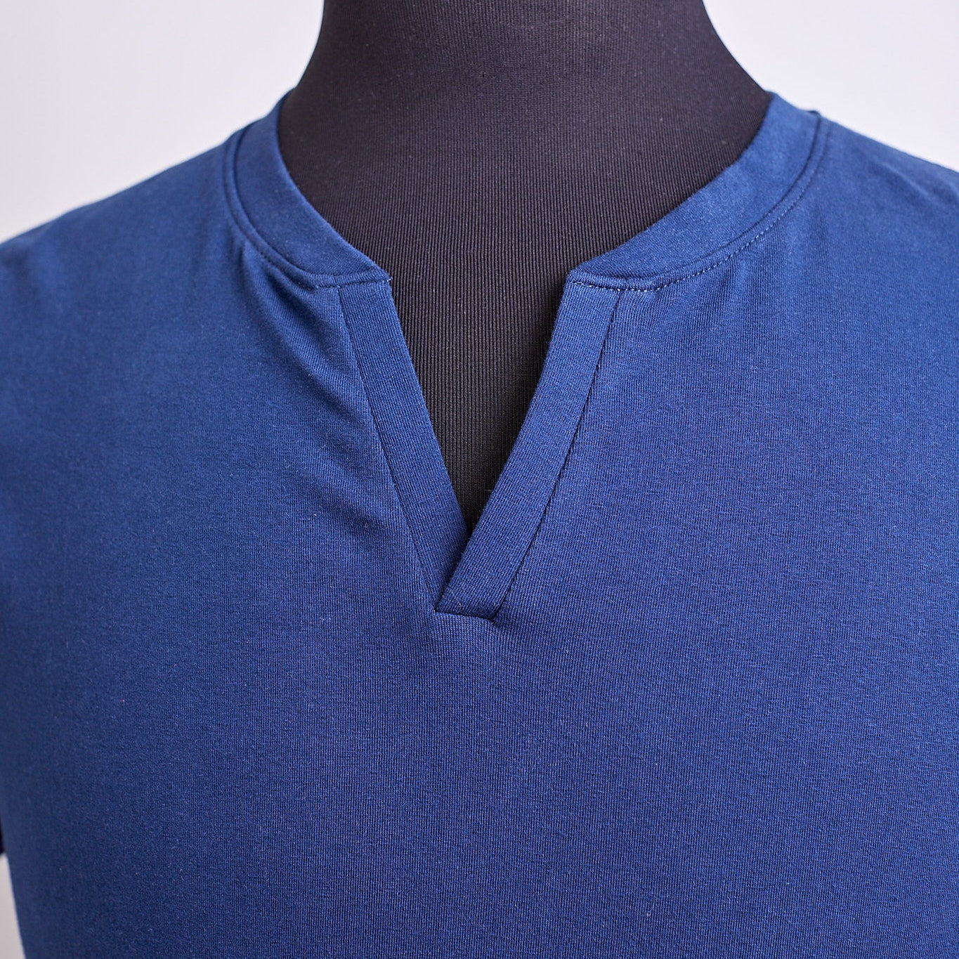 Blue shirt on a mannequin against a plain background